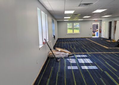 Construction image of the new children's area with a completed ceiling and the carpet cleared for replacement