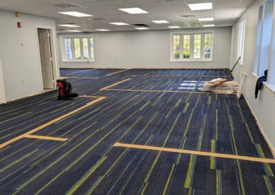 Construction image of the new children's area with a completed ceiling and the carpet cleared for replacement