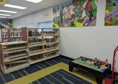 empty shelves in the old picture book area of the children's room with murals above